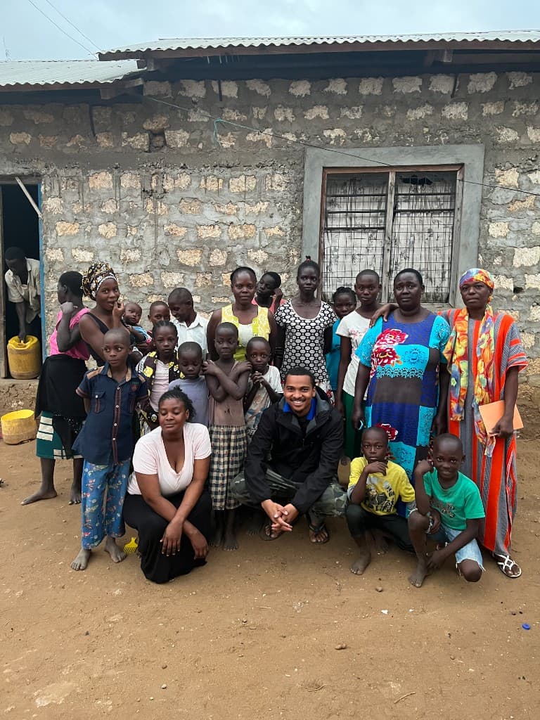 Children and caregivers gathered together outside a community building